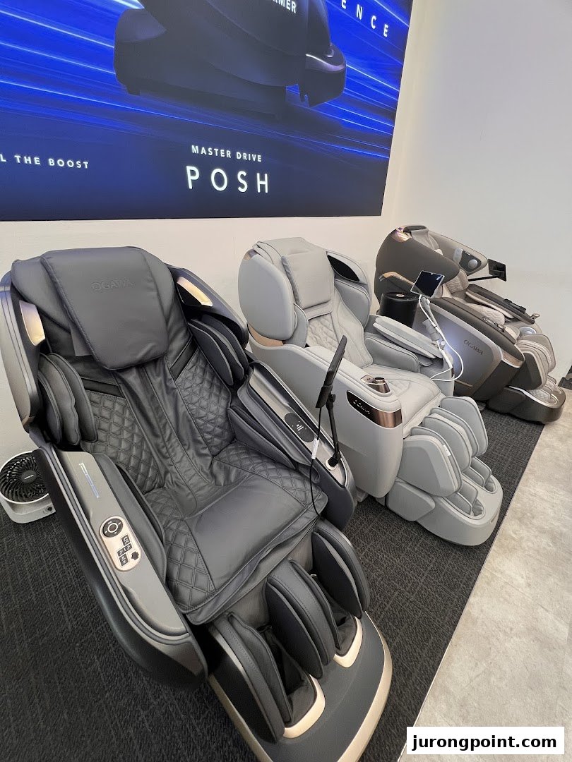 Three modern OGAWA massage chairs displayed in a retail showroom, with a 'MASTER DRIVE POSH' banner.