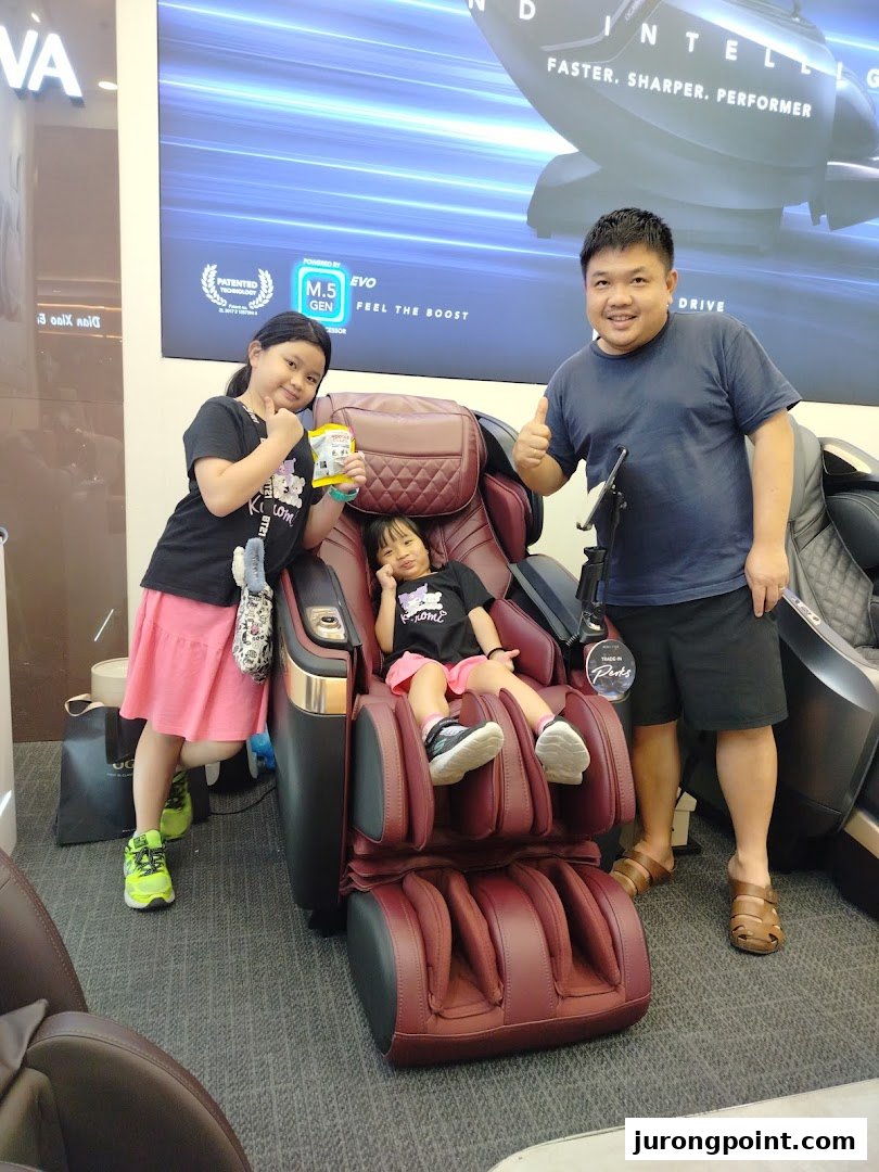 A family happily tests massage chairs at the OGAWA store, highlighting comfort and advanced wellness technology.