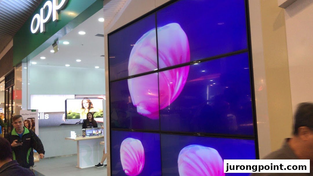 A view of the OPPO Concept Store entrance featuring a large video wall and customers.