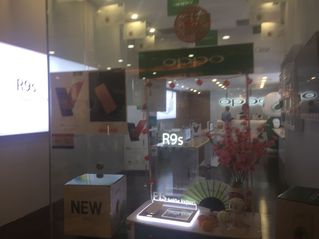 Interior view of an OPPO Concept Store with smartphone displays and festive decorations.