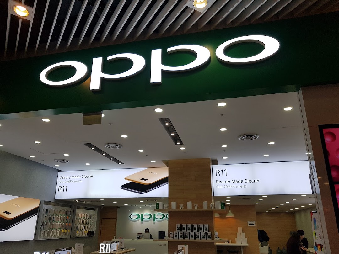 The illuminated OPPO logo above the entrance of a modern concept store, showcasing the R11 phone.