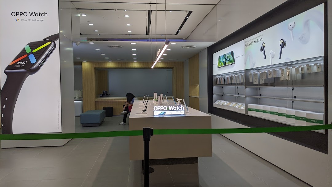 Interior view of an OPPO Concept Store showcasing smartwatches, headphones, and other tech products on display.