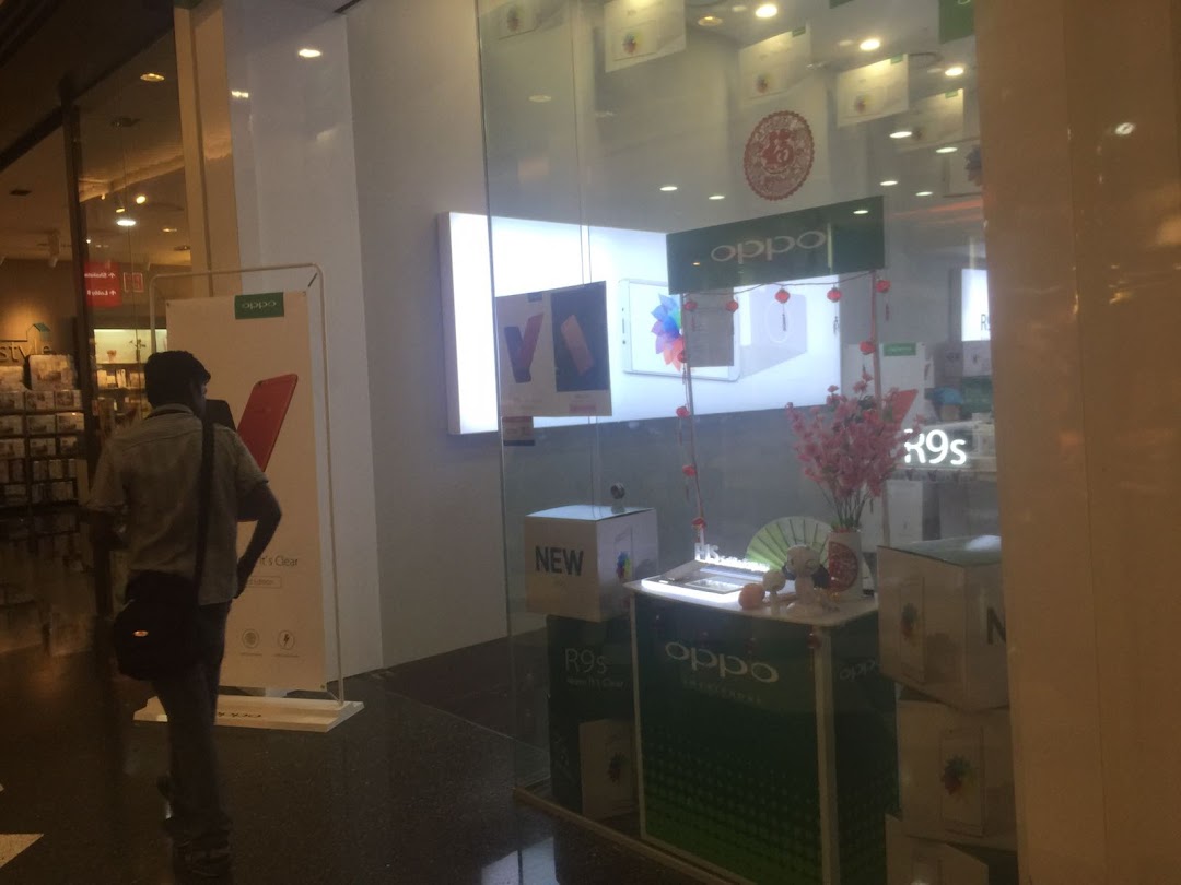 A view of the OPPO Concept Store entrance from the mall corridor, showcasing products and displays.