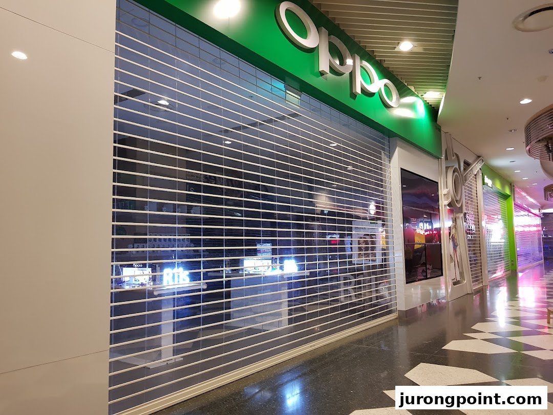 The OPPO Concept Store entrance with a closed security shutter in a shopping mall.