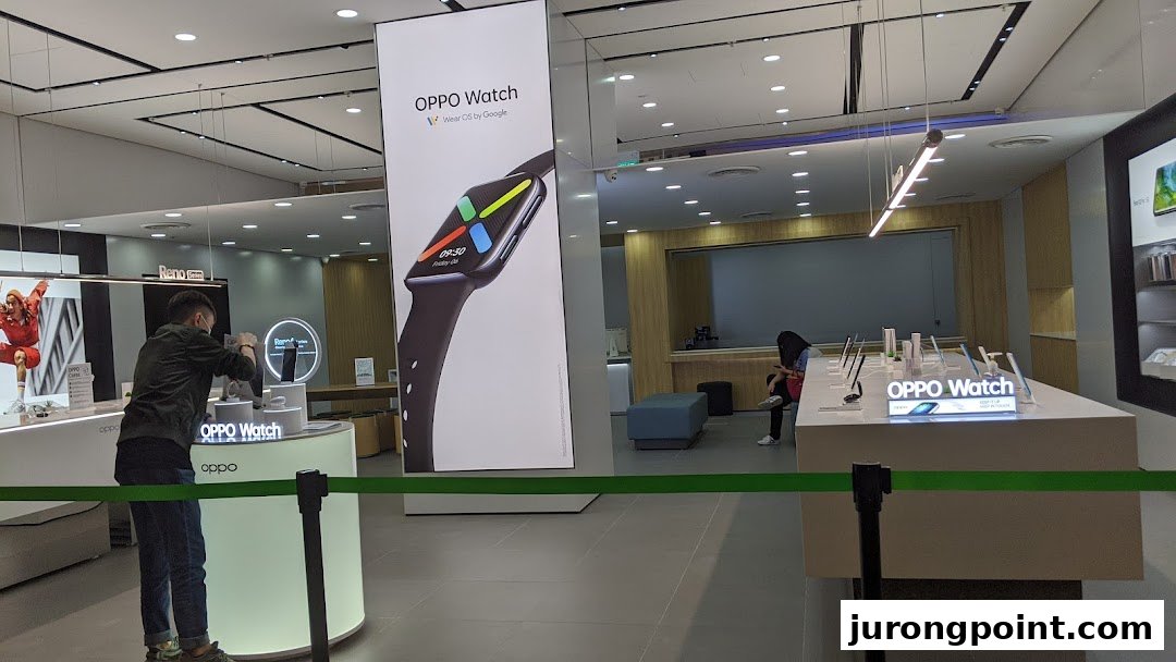 Inside the OPPO Concept Store, featuring a large OPPO Watch display and interactive product showcases.
