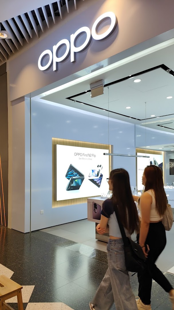 The entrance of an OPPO Concept Store featuring its prominent logo and an interior display with people walking past.
