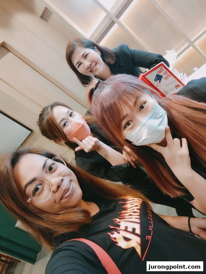 Four smiling individuals, likely staff or customers, inside Oriental Hair Solutions.