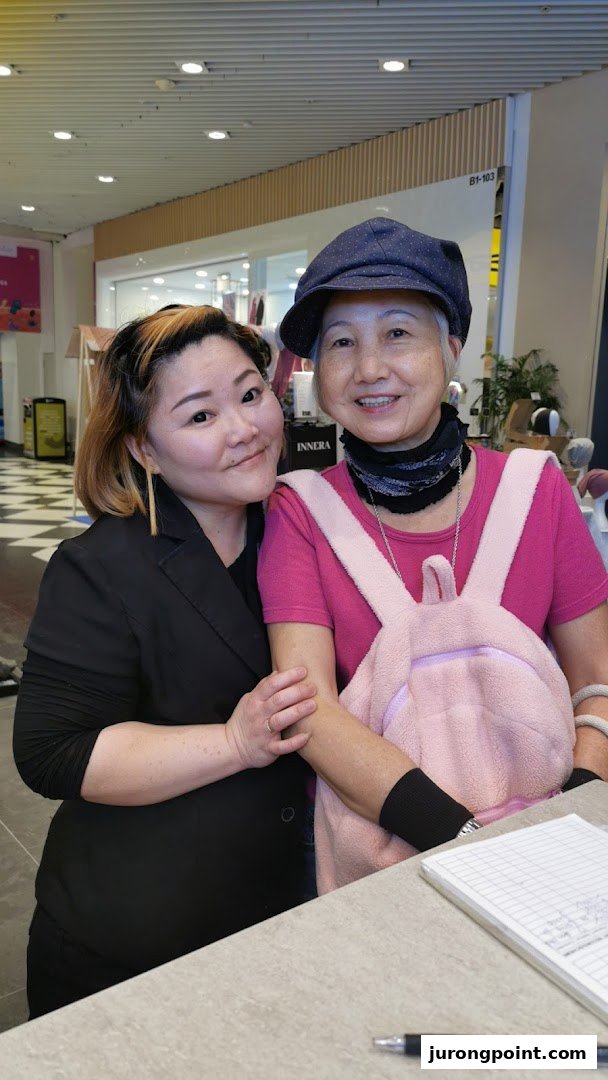 Two women, one possibly a staff member, smiling at the counter of Oriental Hair Solutions.