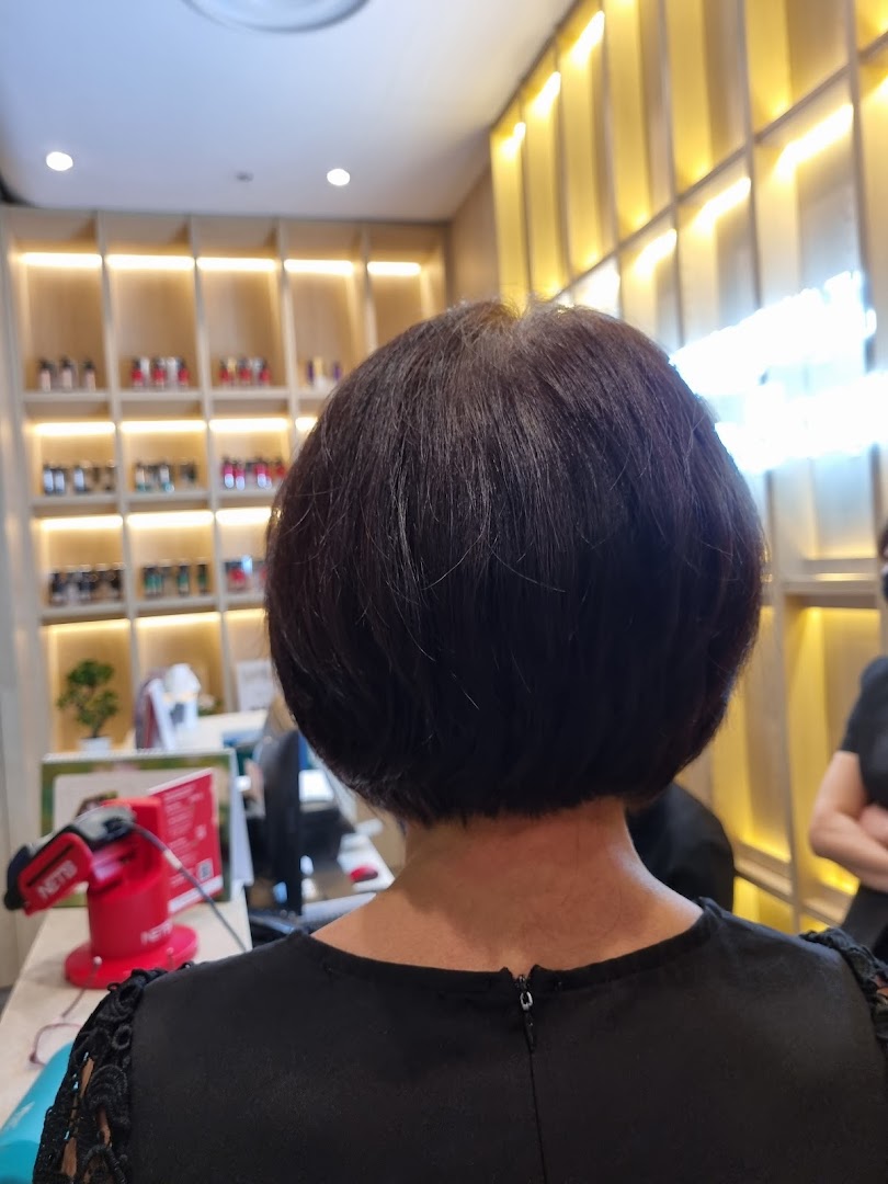 A client's freshly styled short haircut, viewed from behind, inside Oriental Hair Solutions salon.