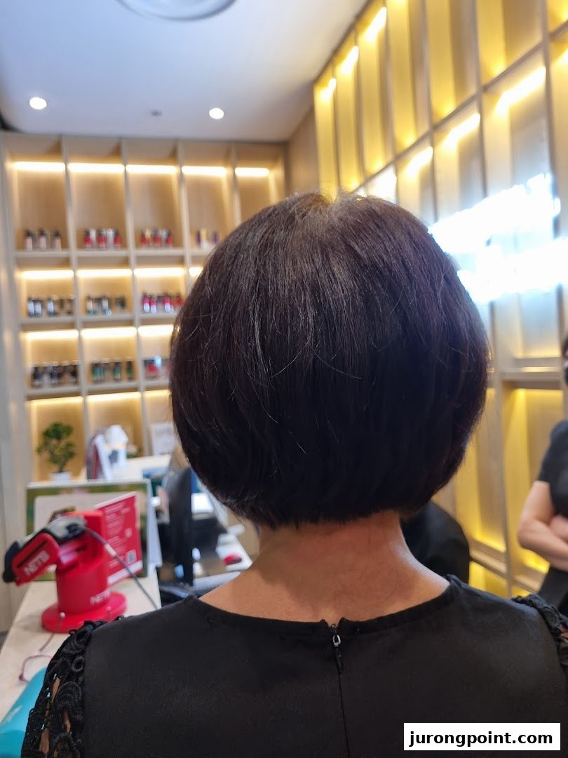 A client's freshly styled short haircut, viewed from behind, inside Oriental Hair Solutions salon.