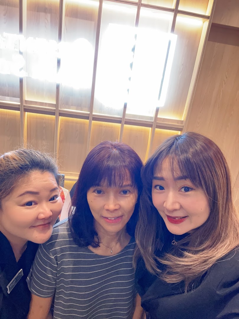 Three women smiling and posing for a photo inside Oriental Hair Solutions.