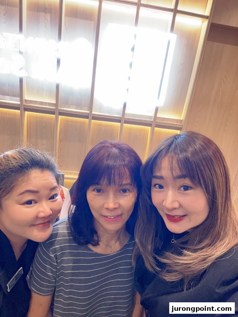 Three women smiling and posing for a photo inside Oriental Hair Solutions.