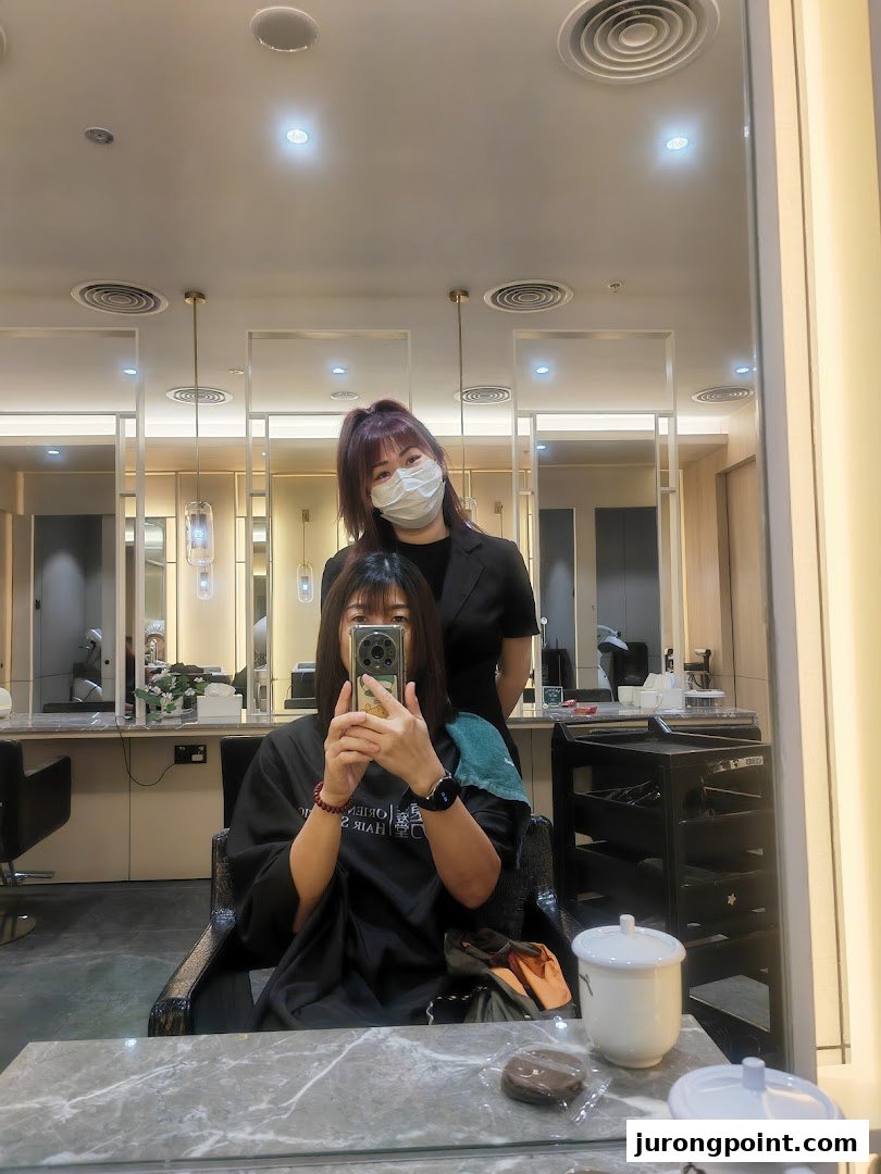 Customer and stylist captured in a mirror selfie, showcasing a professional salon experience.