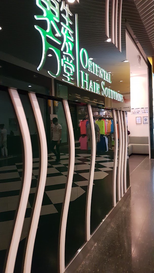 The illuminated storefront of Oriental Hair Solutions, showcasing its distinctive signage and entrance.
