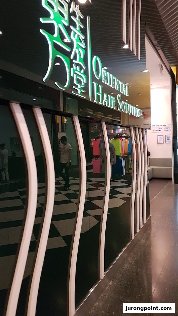 The illuminated storefront of Oriental Hair Solutions, showcasing its distinctive signage and entrance.
