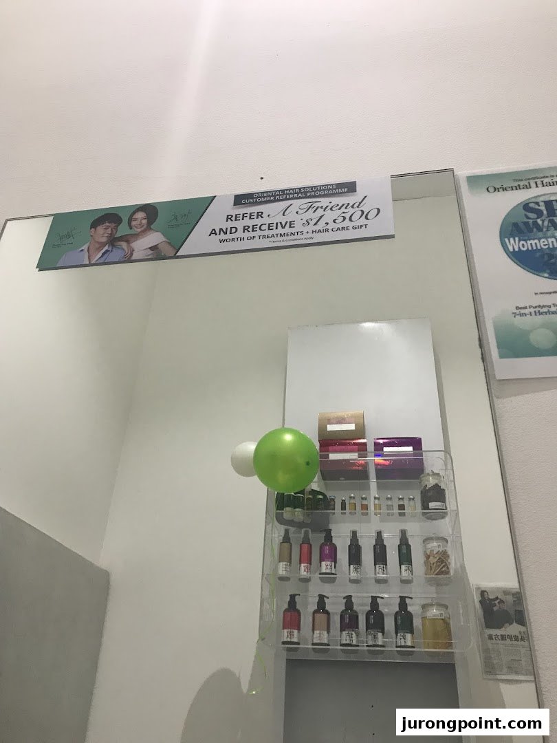 An interior view of Oriental Hair Solutions showcasing hair care products, a referral program banner, and awards.