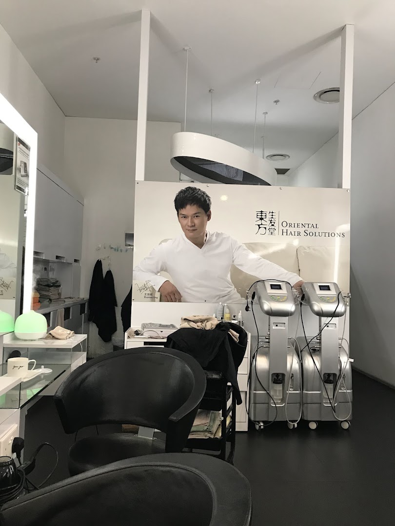Interior view of Oriental Hair Solutions, featuring a large promotional banner and hair treatment equipment.