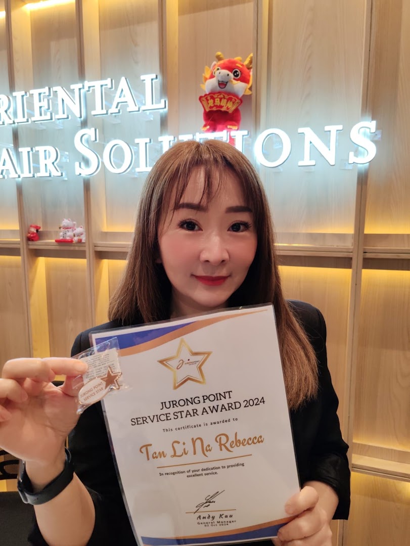 A staff member from Oriental Hair Solutions proudly displays a Jurong Point Service Star Award 2024.