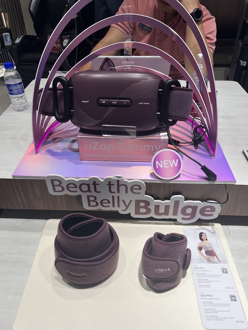 OSIM uZap Tummy vibrating abdominal massager and other wellness products displayed in a retail setting.