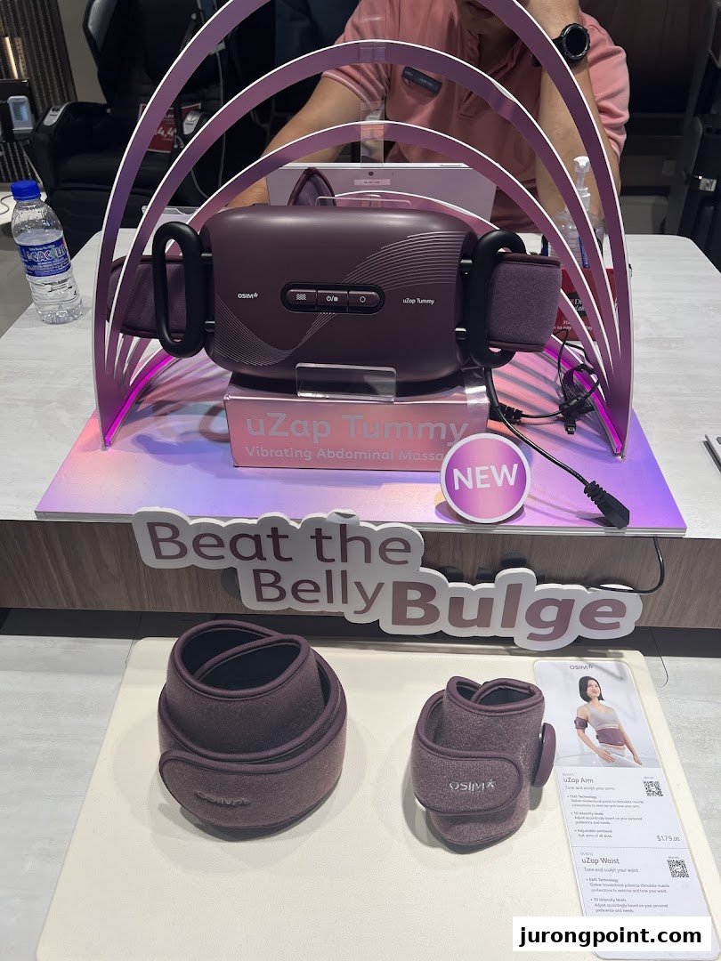 OSIM uZap Tummy vibrating abdominal massager and other wellness products displayed in a retail setting.
