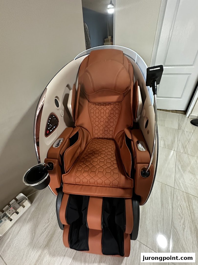 A luxurious brown and black OSIM massage chair with a cup holder and tablet stand.