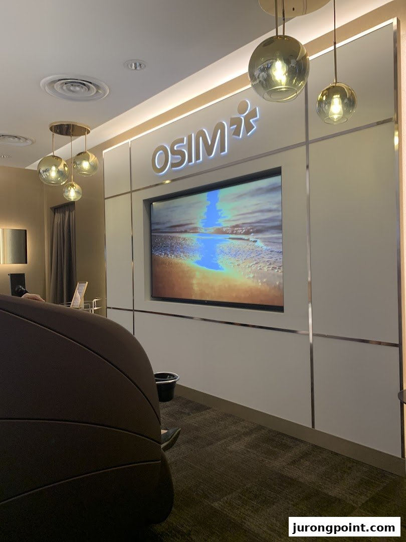 Interior view of an OSIM store featuring a large screen, brand logo, and a comfortable massage chair.