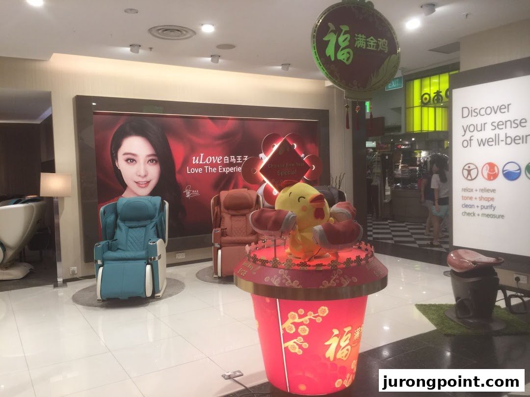 Interior view of an OSIM store featuring massage chairs, a promotional display, and wellness marketing.