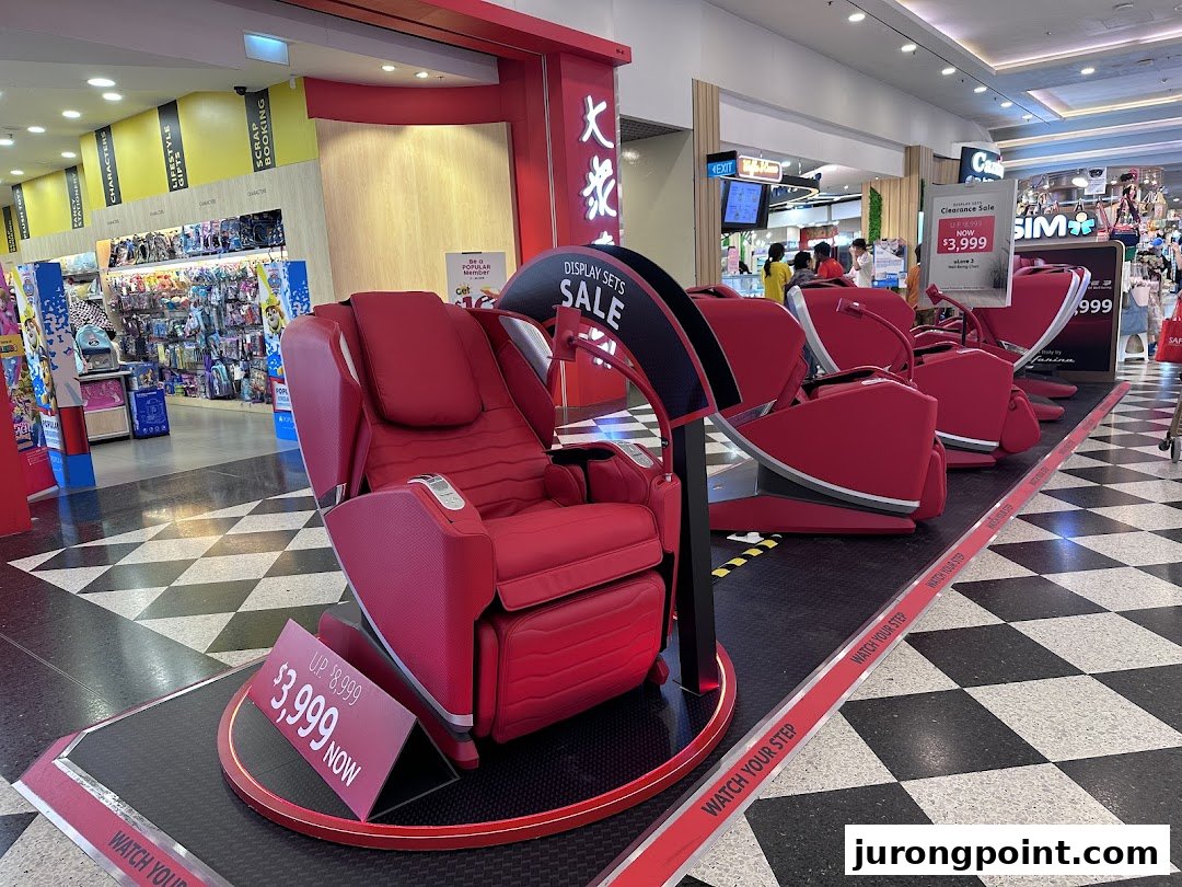 Red OSIM massage chairs are displayed in a mall walkway, featuring a clearance sale.