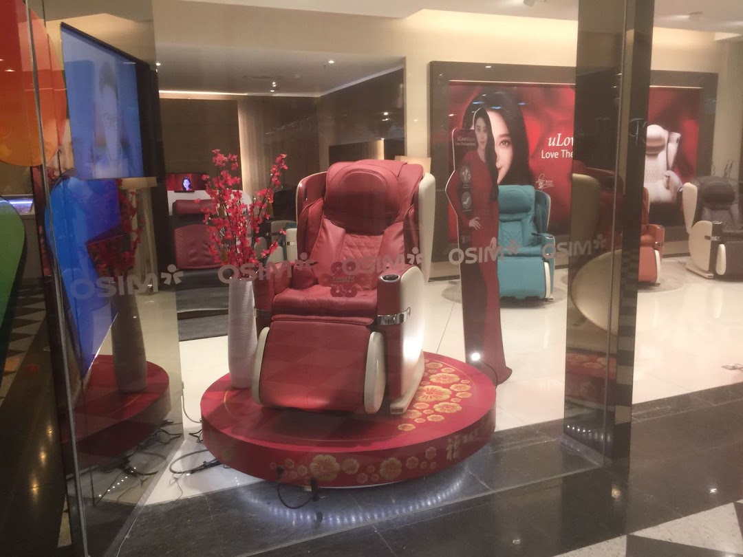A vibrant red massage chair prominently displayed at the entrance of the OSIM store, inviting relaxation.