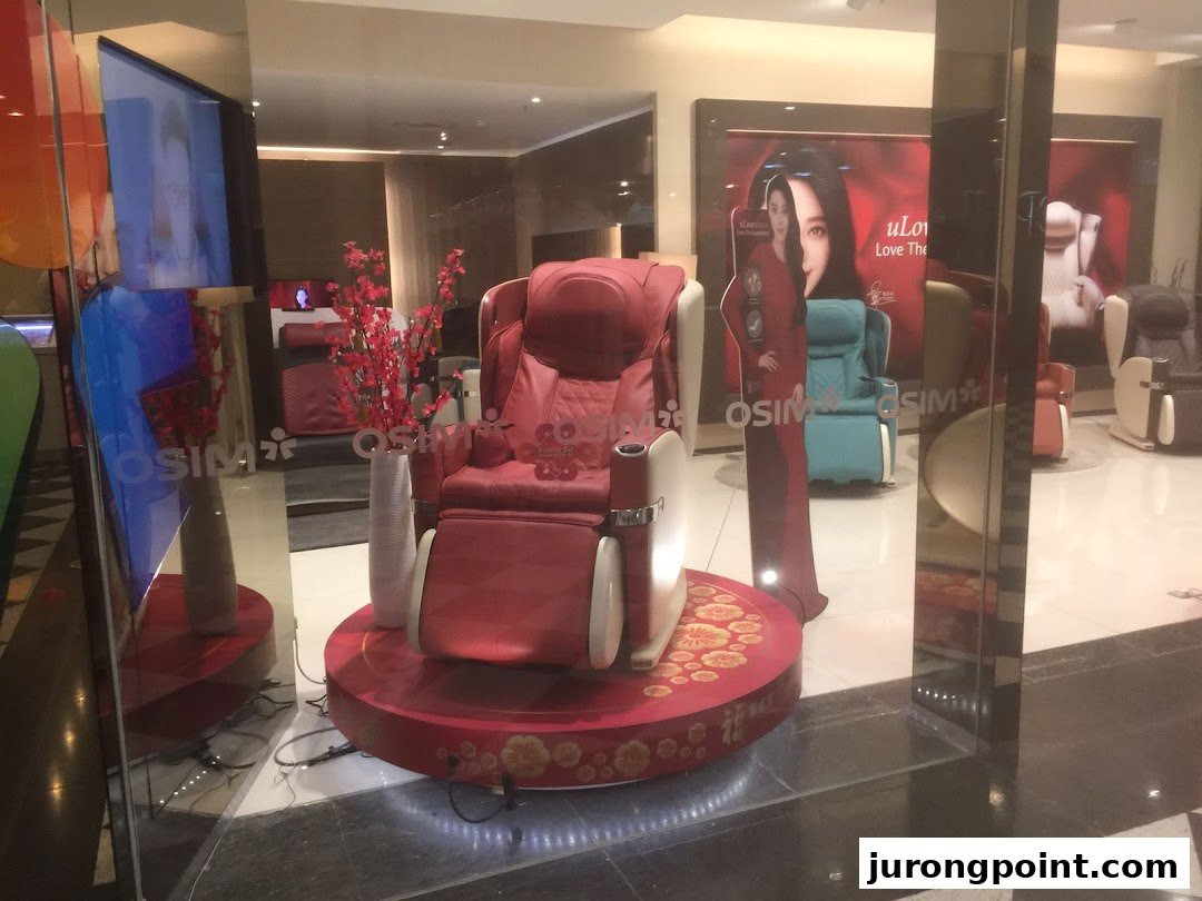 A vibrant red massage chair prominently displayed at the entrance of the OSIM store, inviting relaxation.