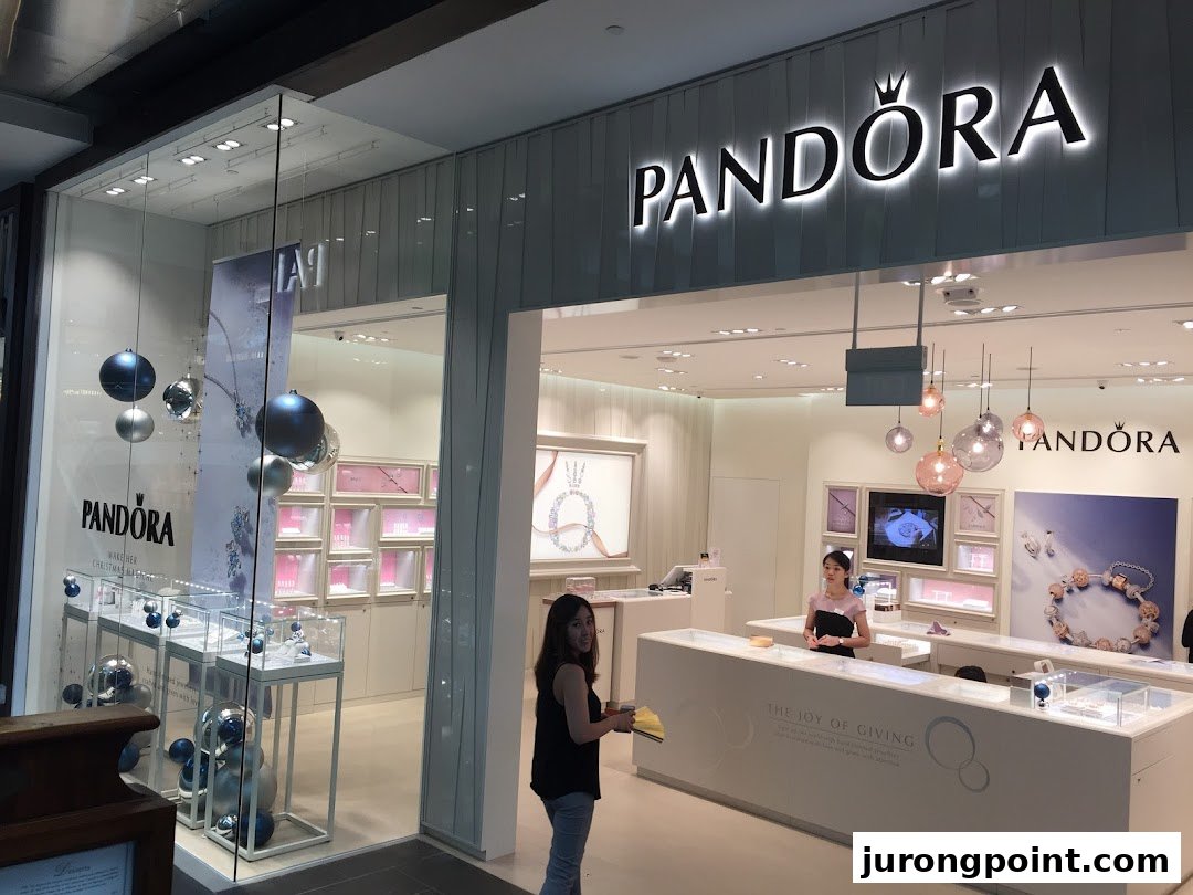 The brightly lit Pandora jewelry store entrance with display windows and interior view.