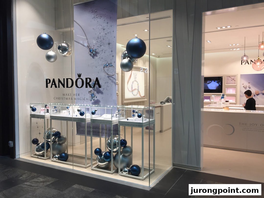 The Pandora shop front features festive displays with jewelry showcases and holiday ornaments.