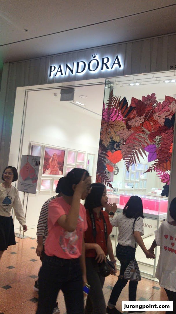 The Pandora jewelry store entrance with its illuminated sign and a decorative window display.