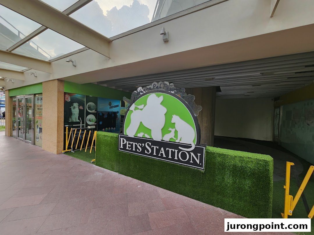 The exterior of Pets Station, a pet supply store, featuring its prominent green and white logo.