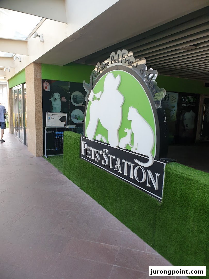 The entrance of Pets Station, featuring a large pet-themed sign and artificial grass decor.