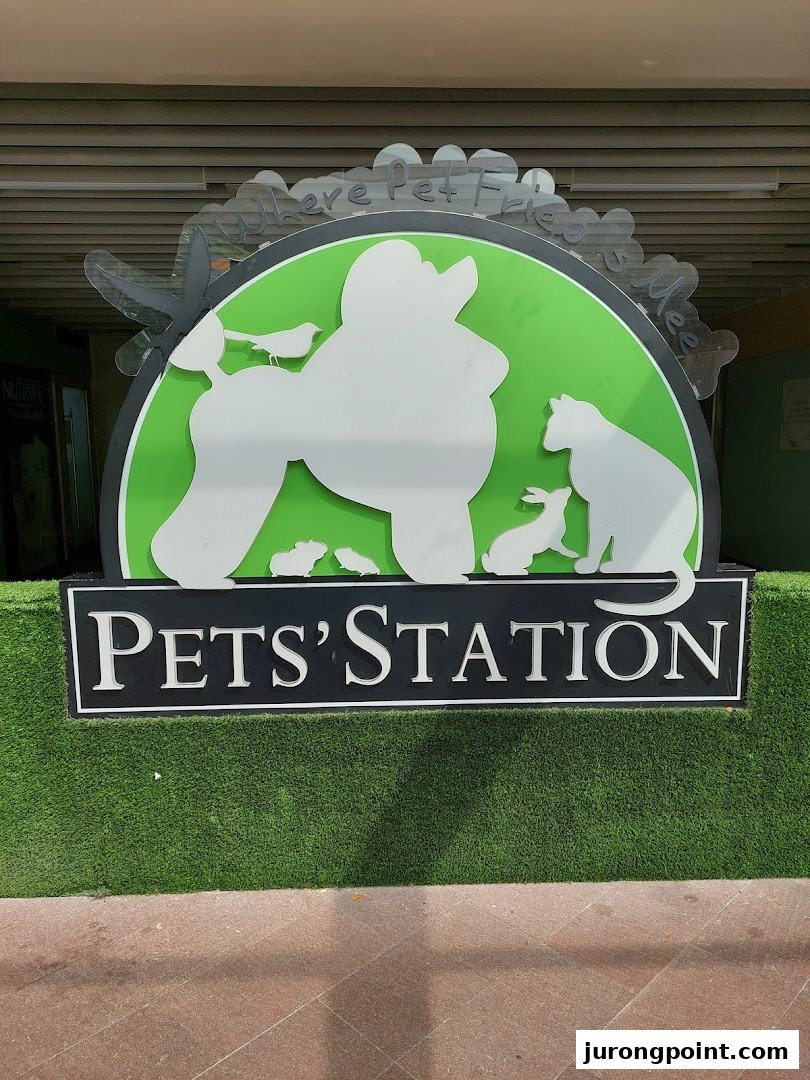 The vibrant green and black shop sign for Pets Station, featuring various animal silhouettes.