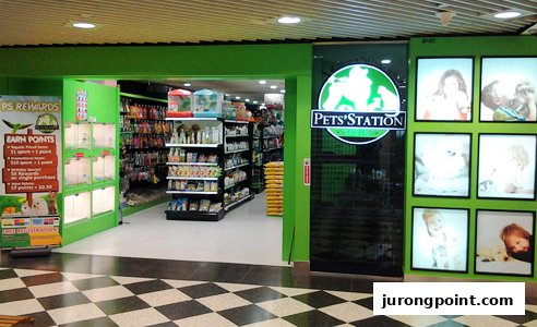 The Pets Station shop front features a bright green entrance, displaying pet supplies and a loyalty program.