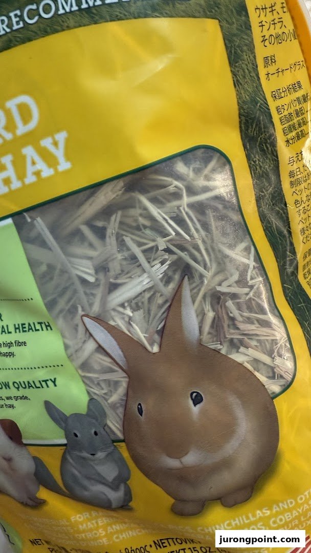 A close-up of a bag of orchard hay for small pets, featuring illustrations of a rabbit and chinchilla.
