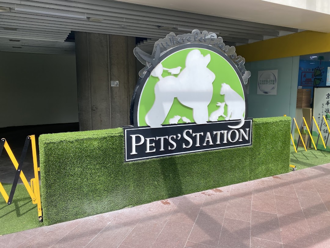 The exterior sign of Pets Station, featuring pet silhouettes and artificial grass landscaping.