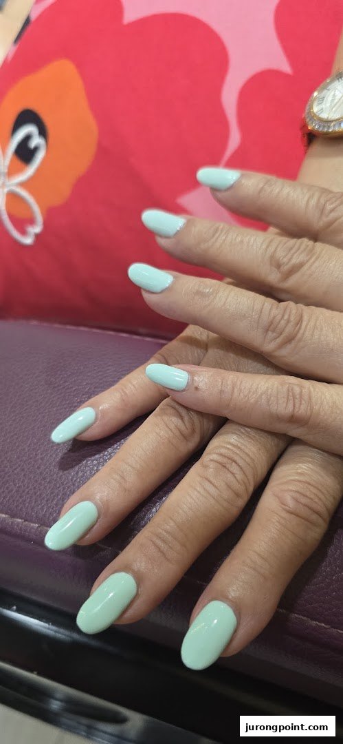 Close-up of hands with freshly manicured, long, light blue nails, showcasing a nail service.