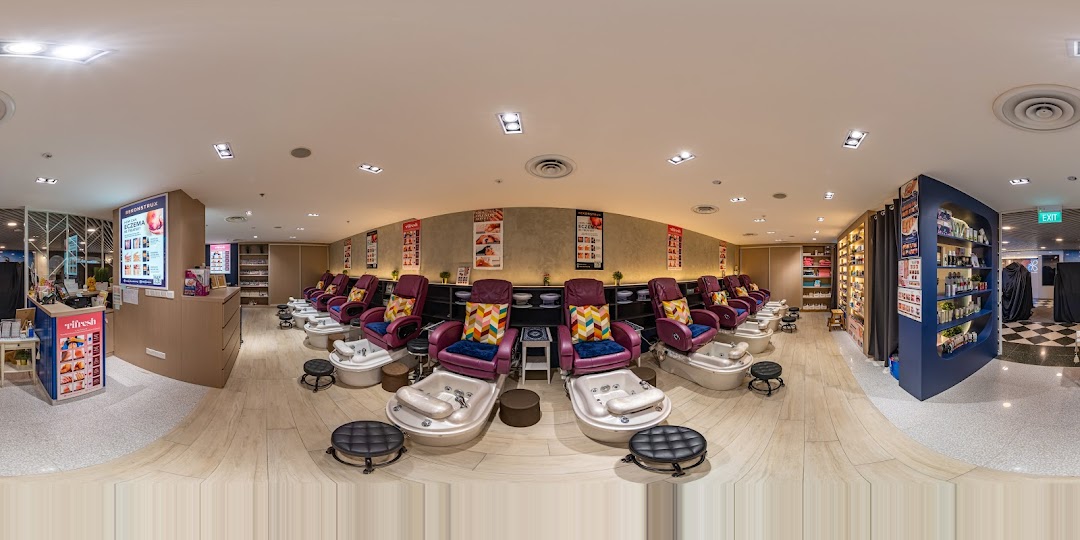 A wide-angle view of Pixie Nail Spa's interior, featuring multiple comfortable pedicure chairs and product displays.