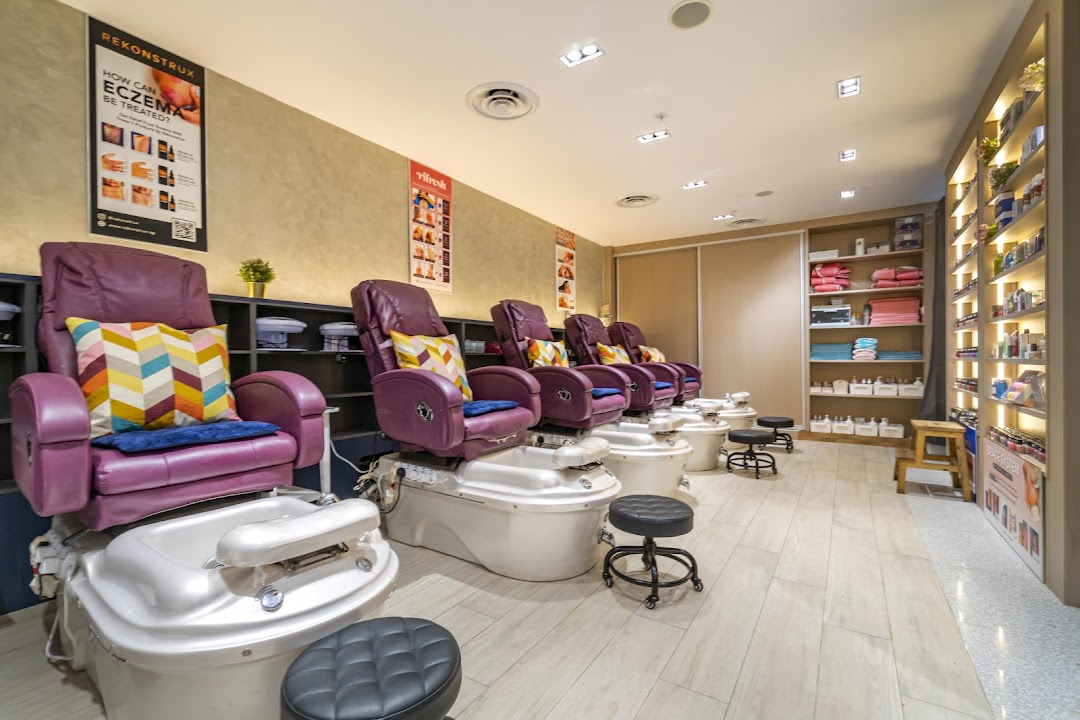 Interior view of Pixie Nail Spa featuring multiple comfortable pedicure stations with purple chairs.