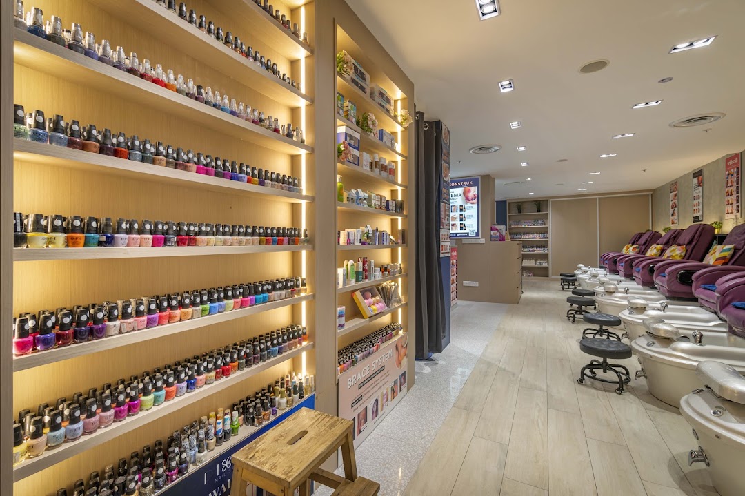 Interior view of Pixie Nail Spa, showcasing a vast collection of nail polishes and comfortable pedicure stations.