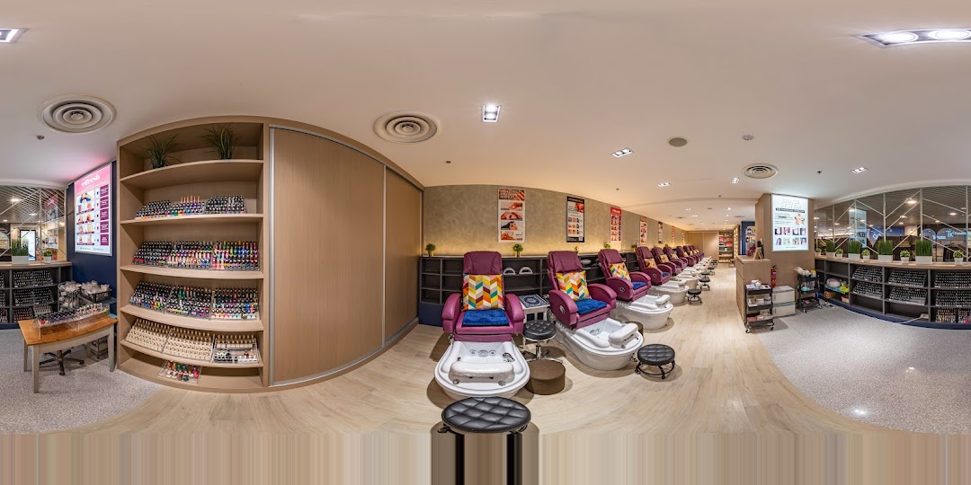 A panoramic view of Pixie Nail Spa's interior, featuring comfortable pedicure stations and extensive nail polish displays.