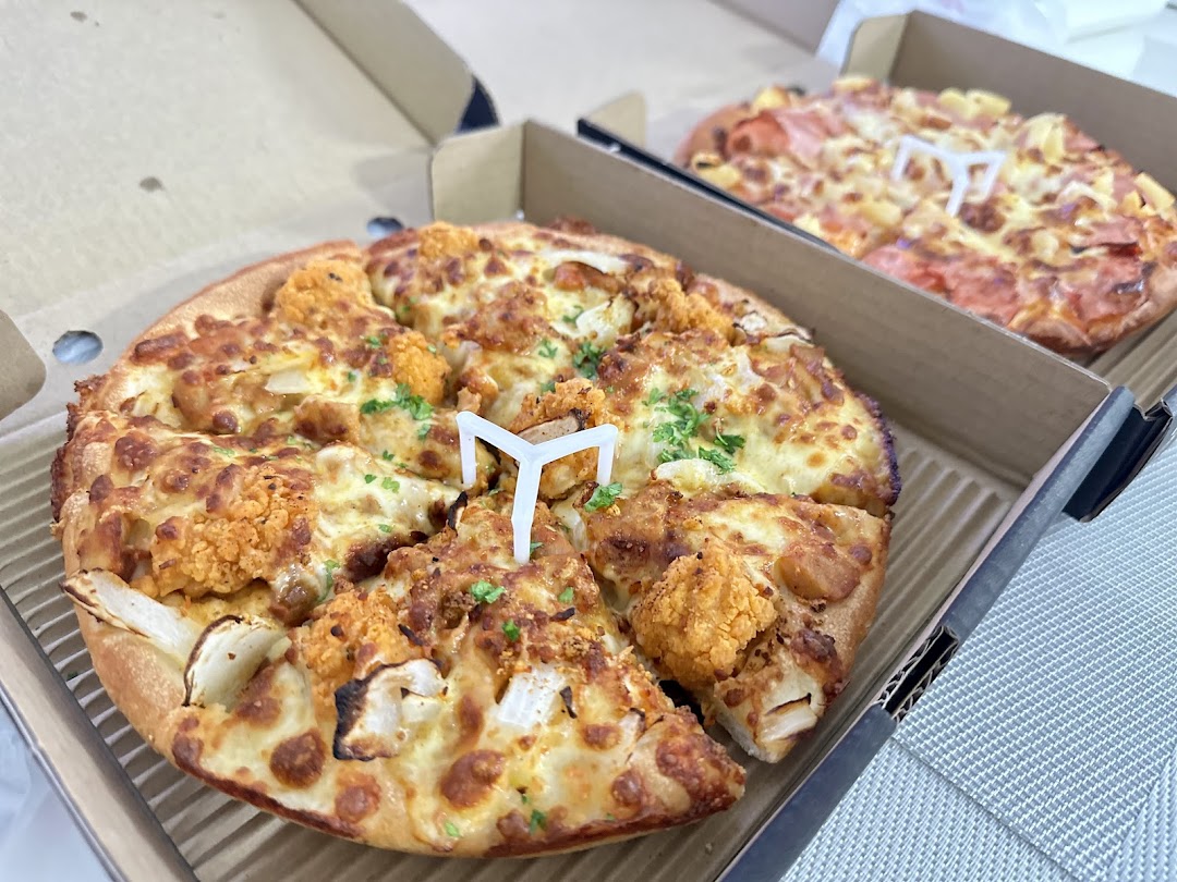 Two delicious pizzas in open boxes, one with cauliflower and the other with ham and pineapple.