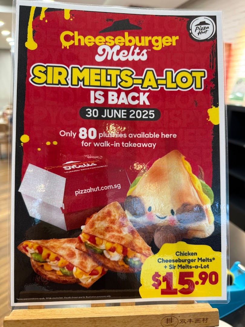 A Pizza Hut promotional standee advertising Cheeseburger Melts and a Sir Melts-a-Lot plushie combo.