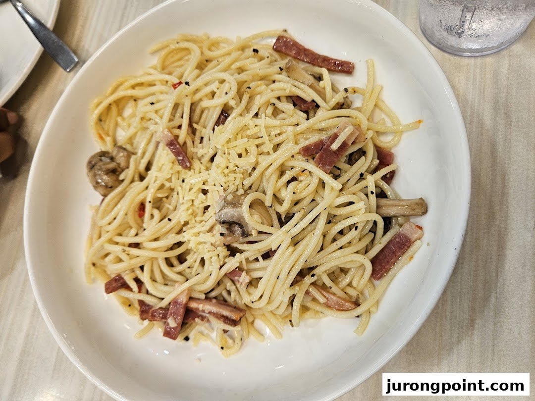 A close-up of a delicious pasta dish with mushrooms, bacon, and grated cheese.