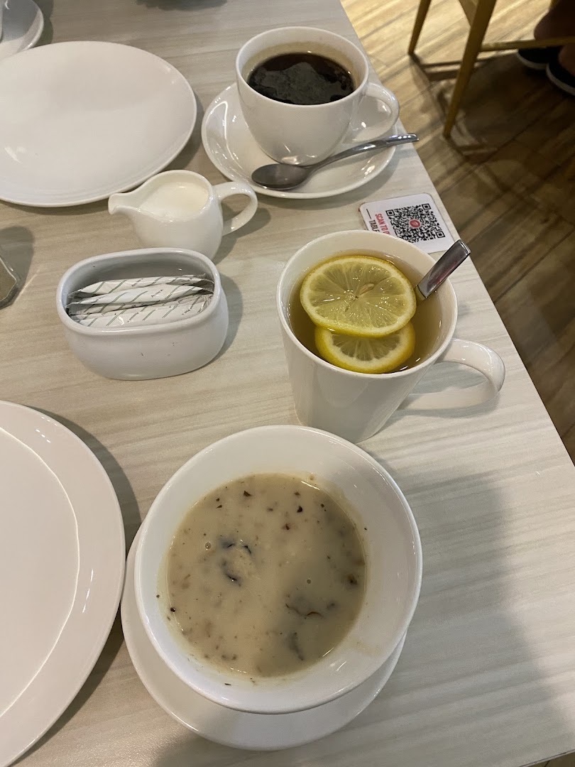 A table setting with mushroom soup, black coffee, and lemon tea at Pizza Hut.