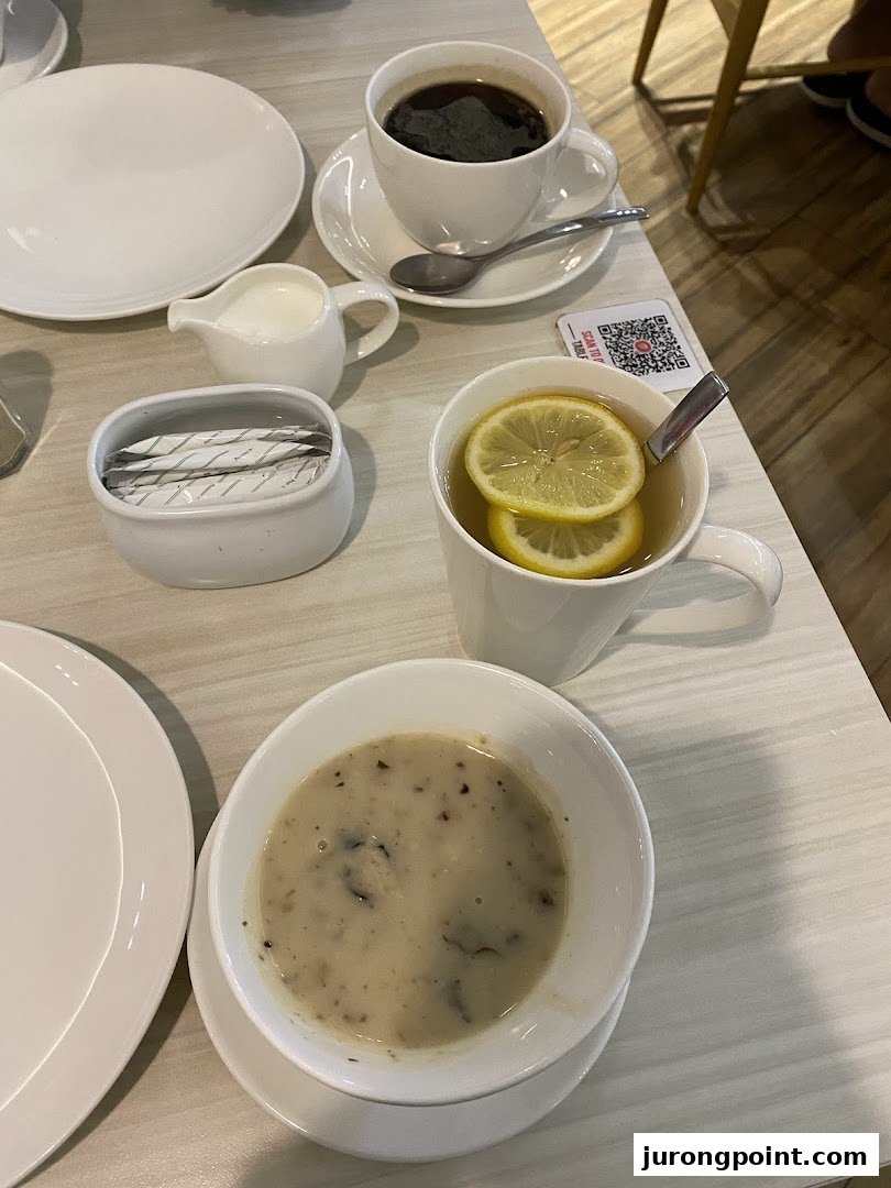 A table setting with mushroom soup, black coffee, and lemon tea at Pizza Hut.