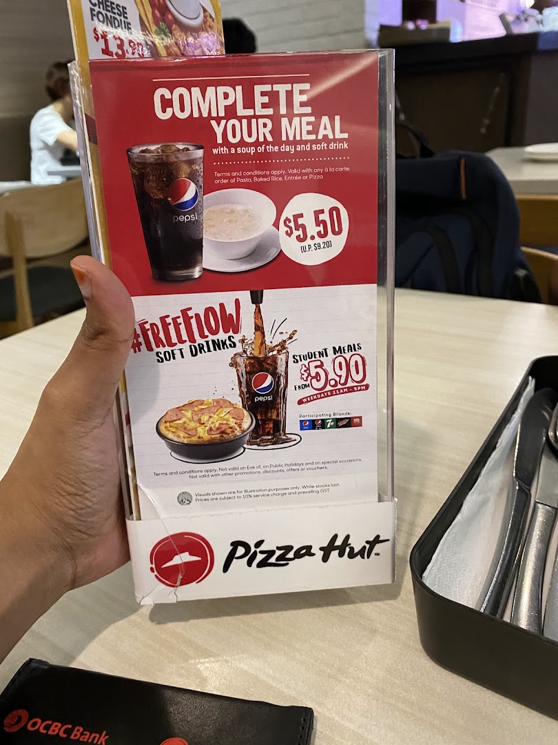 A Pizza Hut table tent displaying promotional meal deals and student offers.